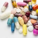 close-up-of-multi-colored-pills-over-white-royalty-free-image-946305674-1554752667